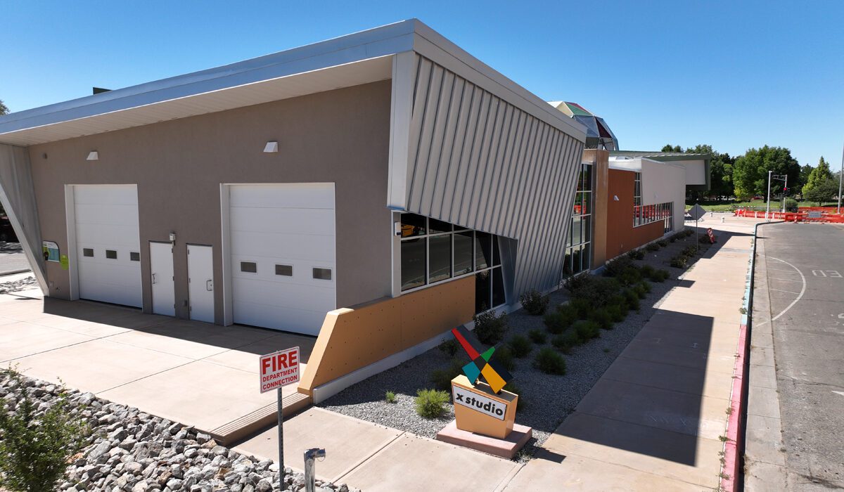 A fire station with a yellow hydrant and a blue sky.